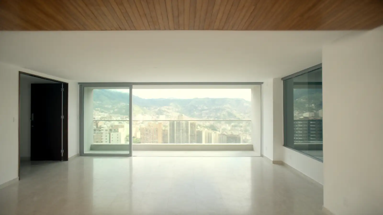 Living room of an El Poblado apartment with a balcony and a view of Medellín